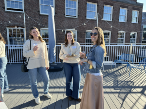 three women standing on an outside patio