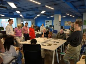 group of people standing around a table in a blue office