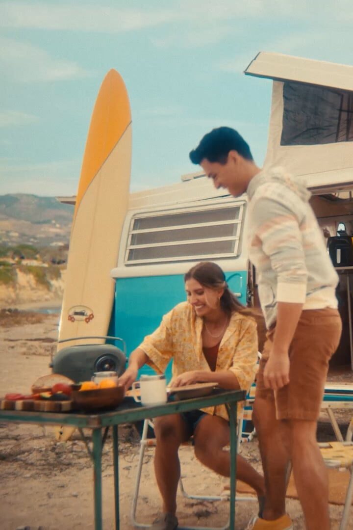 two people eating on a beach