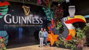 couple standing in front of a guinness wall