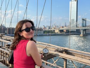 woman standing on bridge overlooking new york city